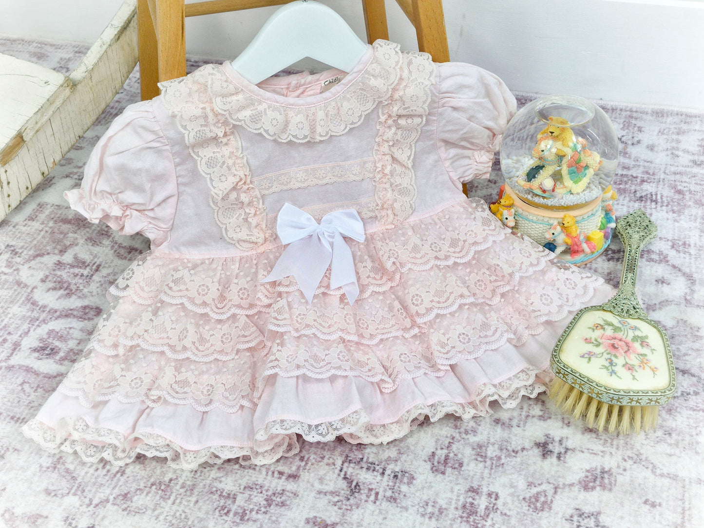 12 months. Pink vintage frilly dress with lace ruffles, puff sleeves and white ribbon