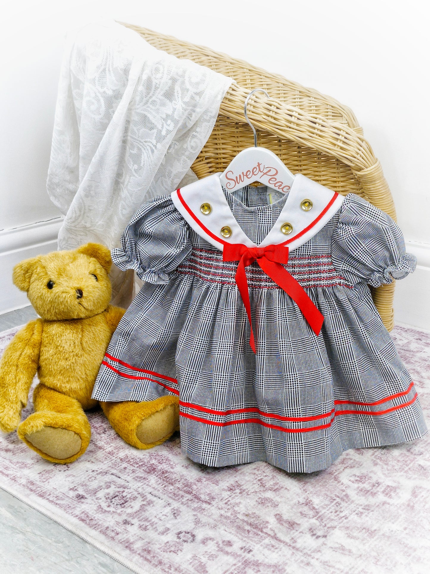 12-18 months. Black and white checked dress with red details and gold buttons
