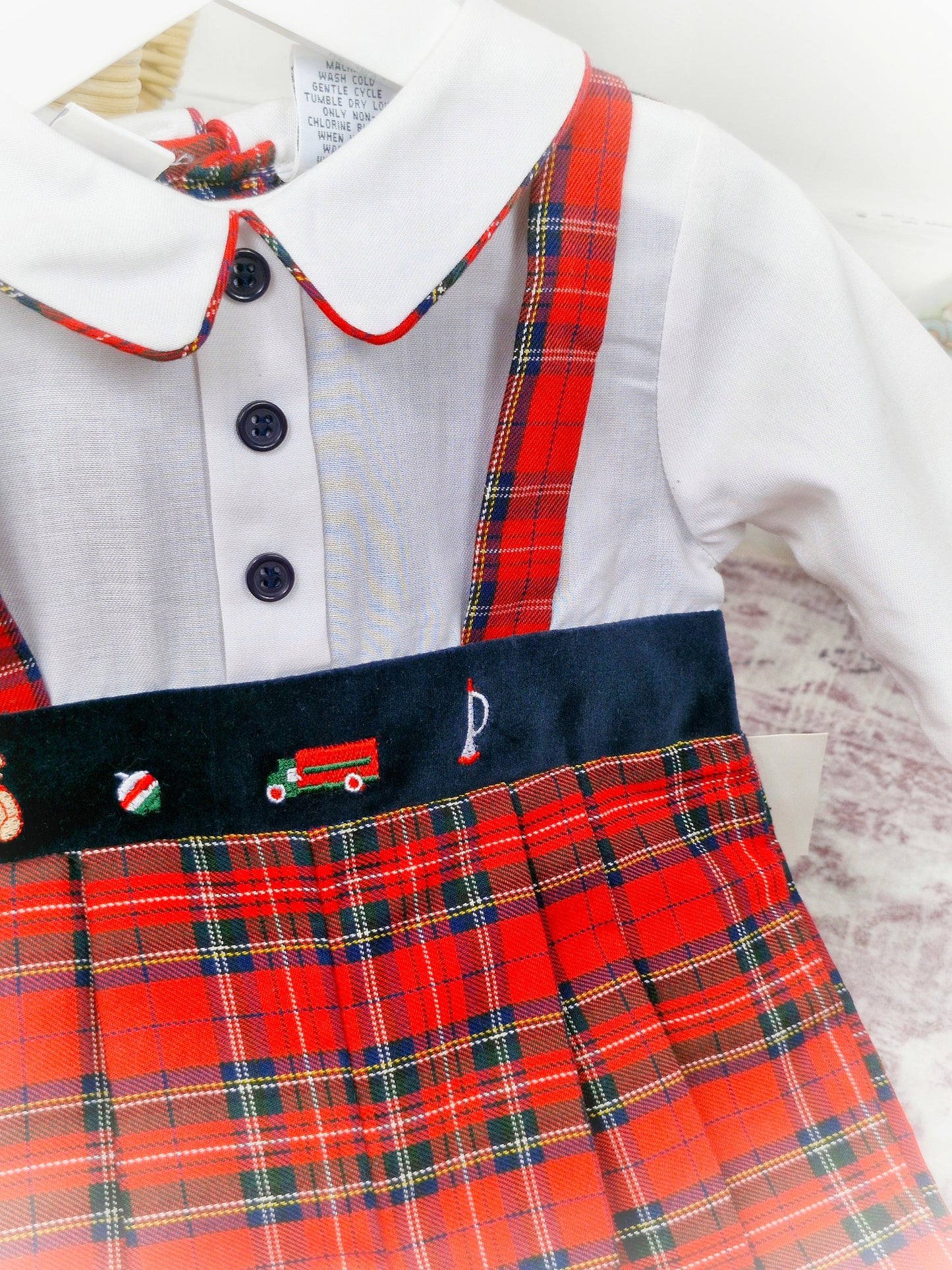 12 months. Red tartan vintage romper, long sleeves, collar and buttons. Embroidered with toys.