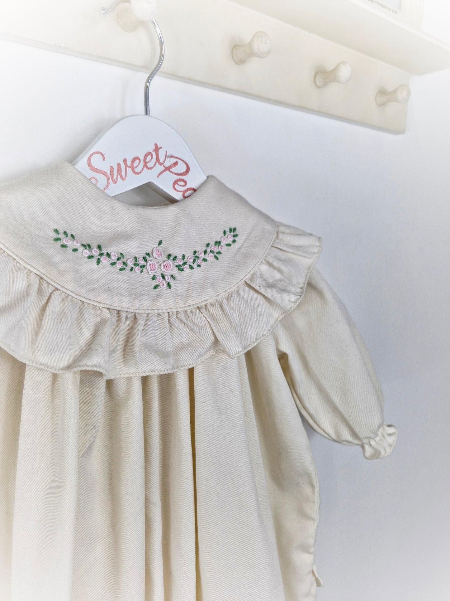 9-12 months Heather Brown romper. Cream with frilly, embroidered bib