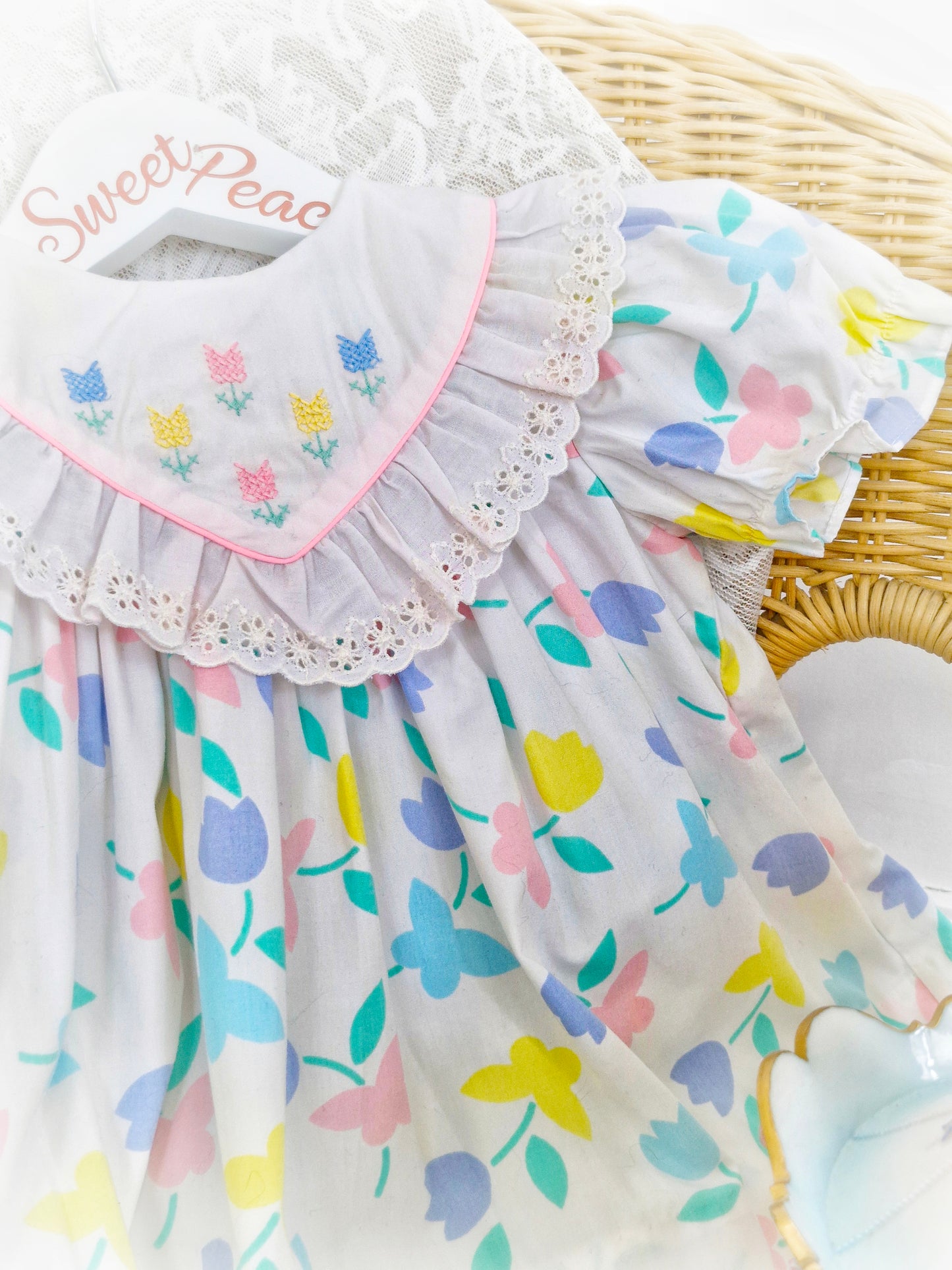 9-12 months. White dress with pastel flowers and butterflies and embroidered bib