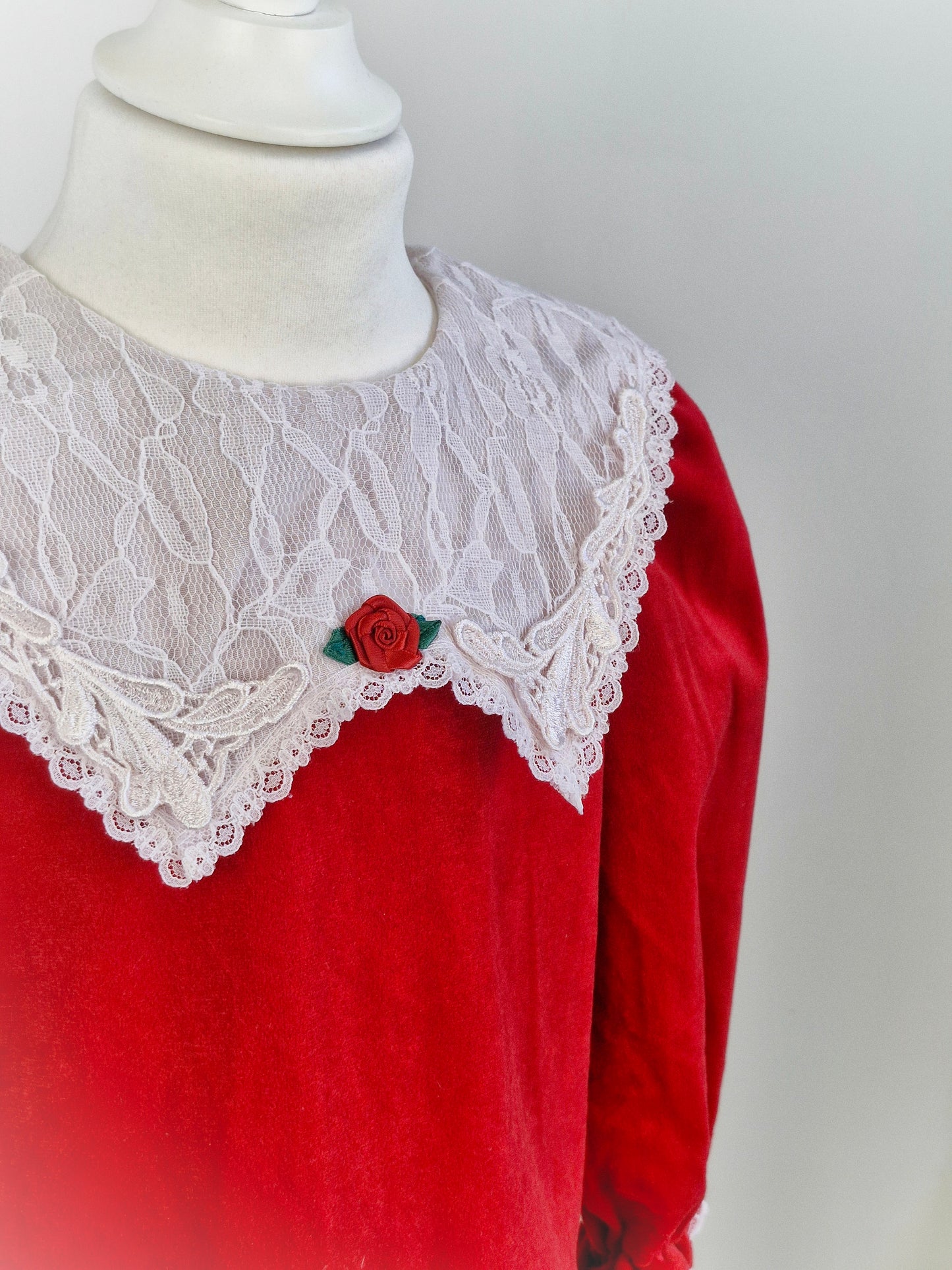 5 years. Red velour dress, white lace bib and trim