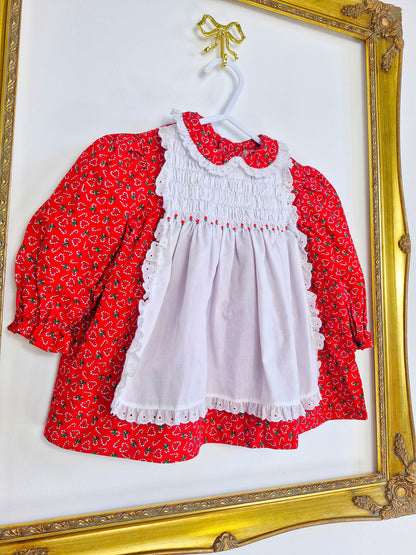 9-12 months. Polly Flinders red dress with candy cane hearts and a white smocked pinny