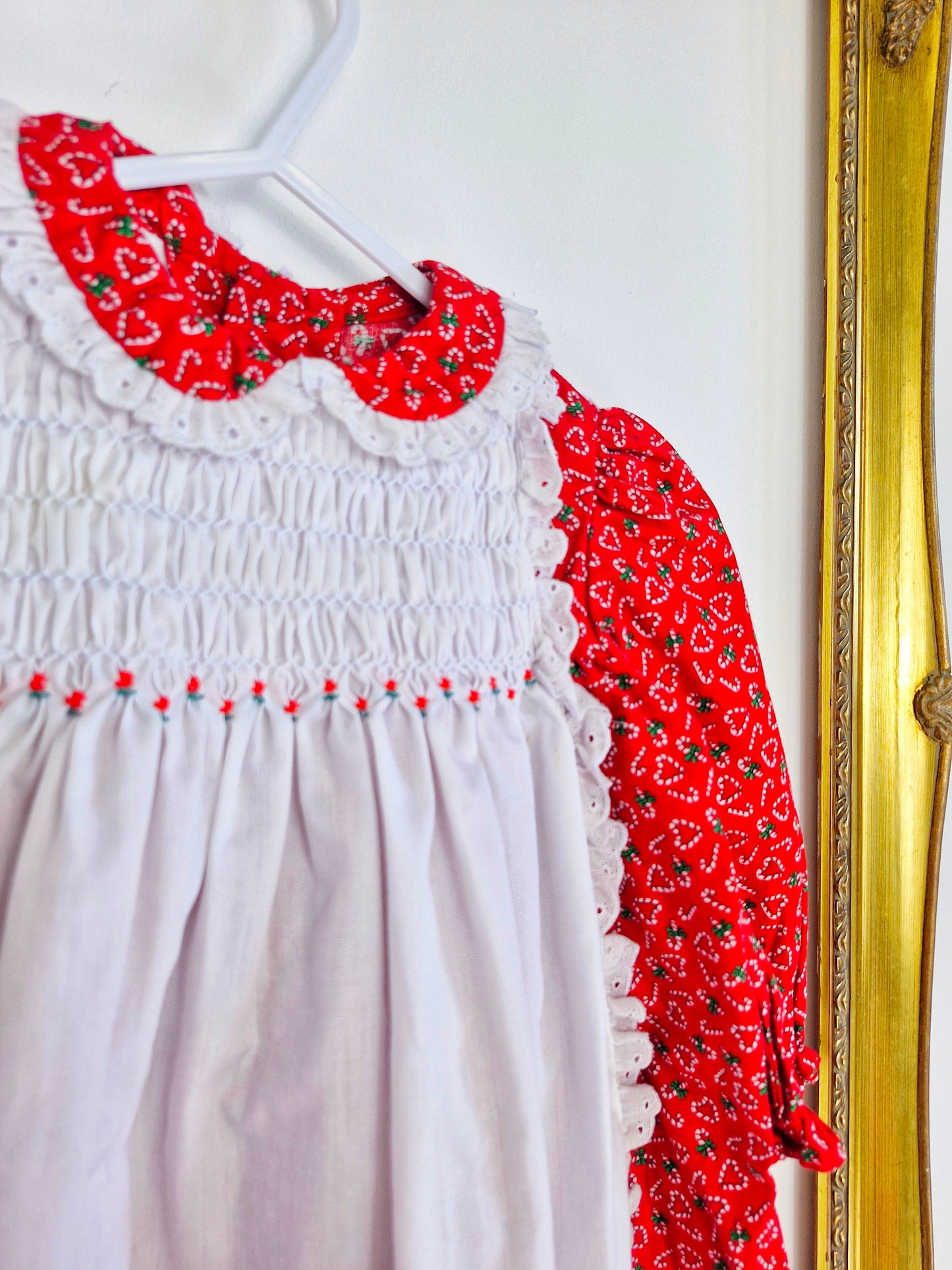 9-12 months. Polly Flinders red dress with candy cane hearts and a white smocked pinny