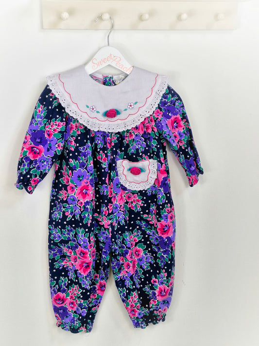 Best fit 18 months. Floral romper with embroidered white bib and pocket