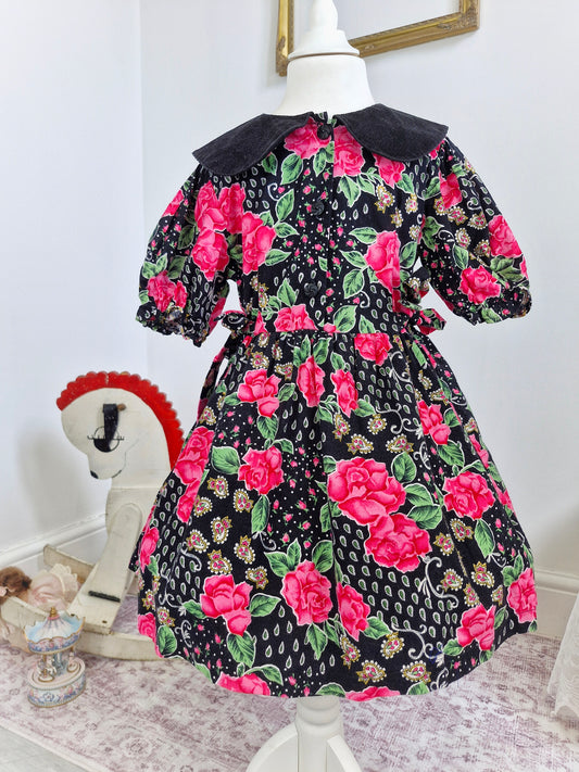 5-6 years. Black dress with pink roses, paisley patterns and a corduroy collar.