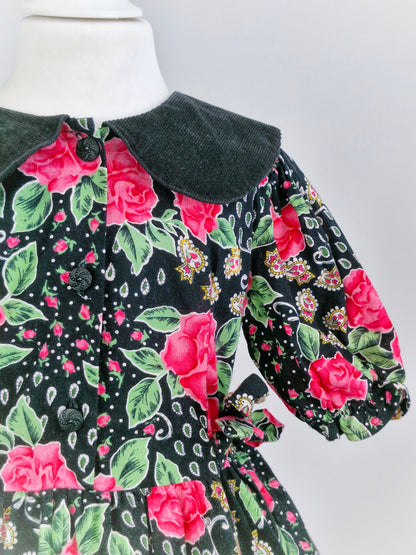 5-6 years. Black dress with pink roses, paisley patterns and a corduroy collar.