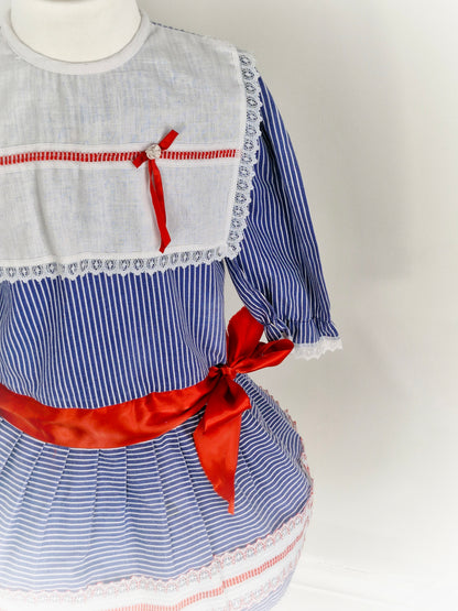 5 years. Blue and white striped vintage Mimix dress, long sleeve with white bib and red ribbon details
