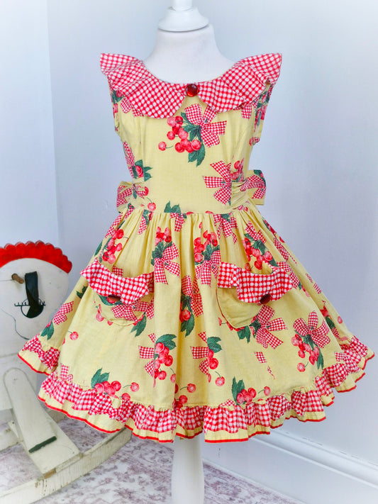4 years. Handmade from vintage Daisy Kingdom fabric. Lemon dress with cherry print, gingham collar, pockets and trim