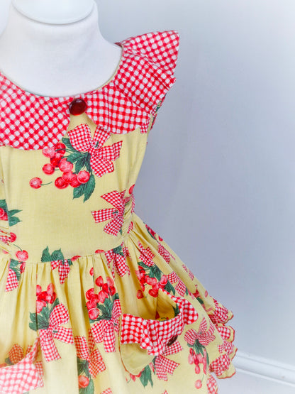 4 years. Handmade from vintage Daisy Kingdom fabric. Lemon dress with cherry print, gingham collar, pockets and trim