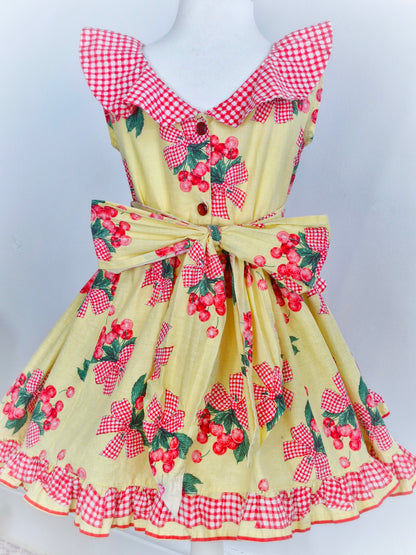 4 years. Handmade from vintage Daisy Kingdom fabric. Lemon dress with cherry print, gingham collar, pockets and trim