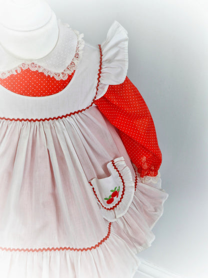 2 years. Red polka dot Bryan with Peter Pan collar and white pinny with flutter sleeves and cherries on pocket.