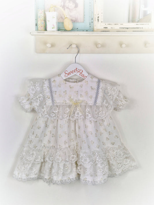 18 months. White dress with lots of lace details and gold glitter patterns