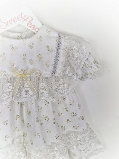 18 months. White dress with lots of lace details and gold glitter patterns