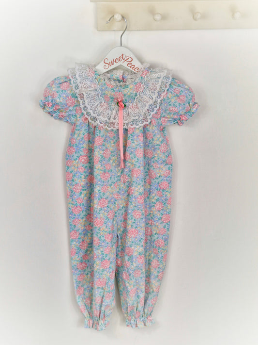 12 months. Pastel floral JoLene romper with lace frills and pink ribbon