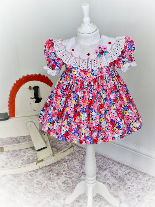 2 years. Ruth of Carolina pink floral vintage dress with white bib embroidered with flowers and lace details
