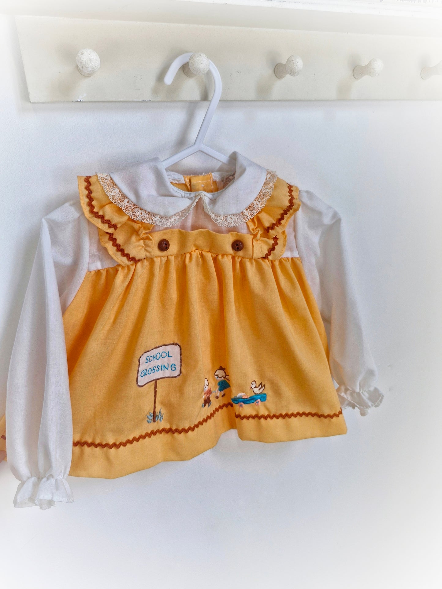 12-18 months. Peach coloured blouse with with sleeves and embroidered "school crossing"