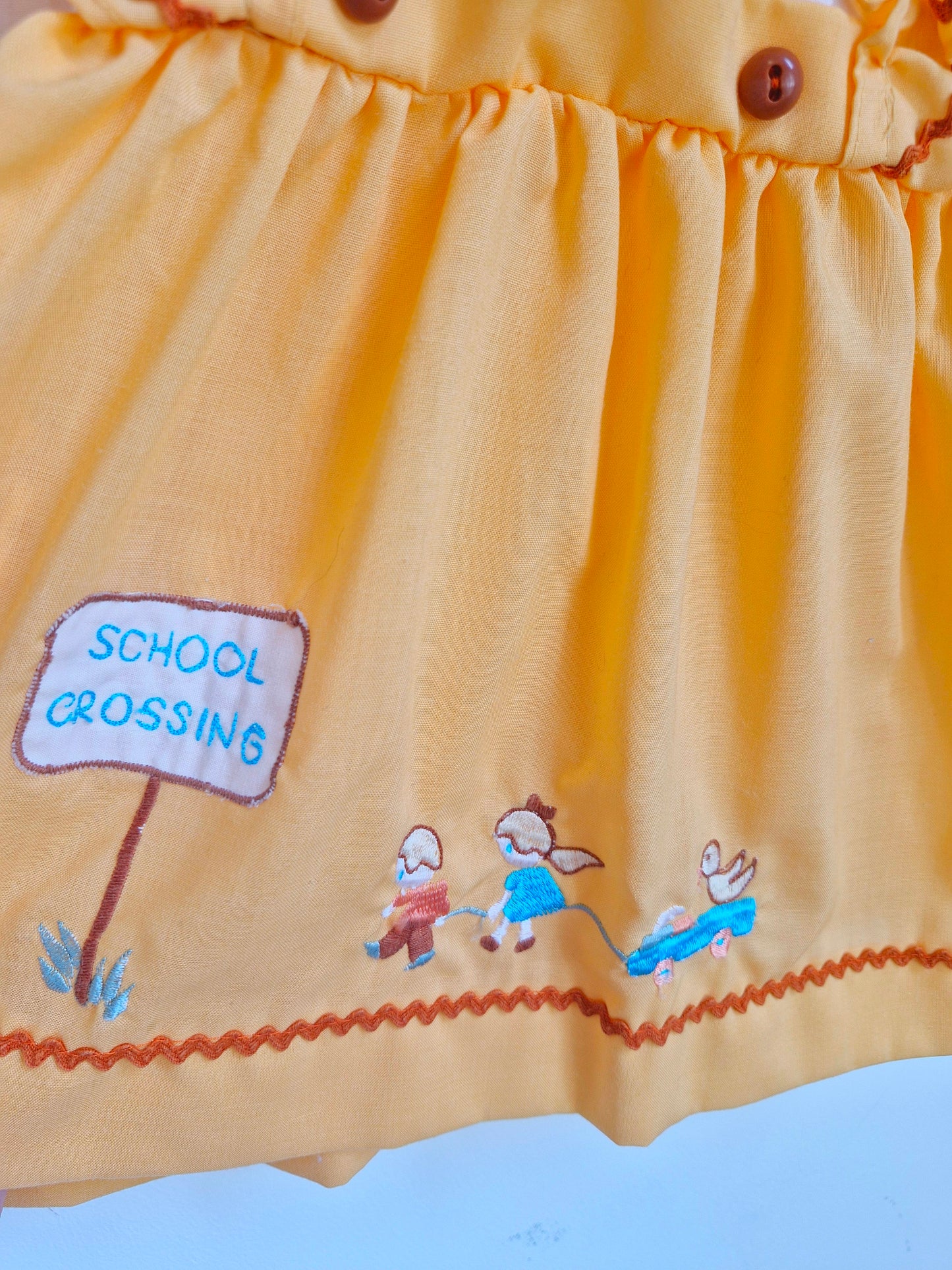 12-18 months. Peach coloured blouse with with sleeves and embroidered "school crossing"