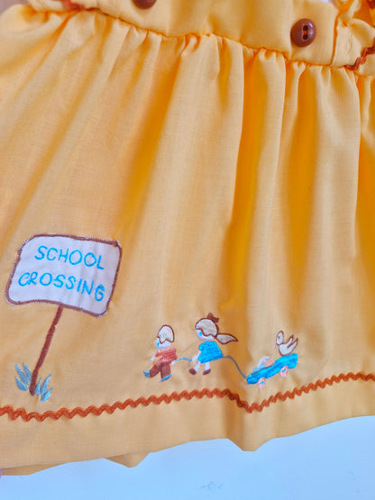 12-18 months. Peach coloured blouse with with sleeves and embroidered "school crossing"