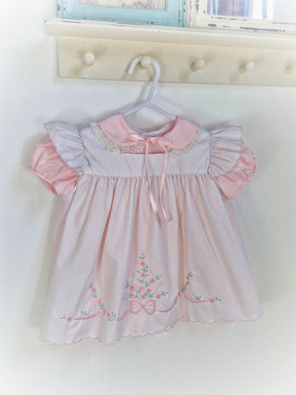 12-18 months. Two piece Nannette vintage pink dress with white pinny embroidered with flowers and bows.