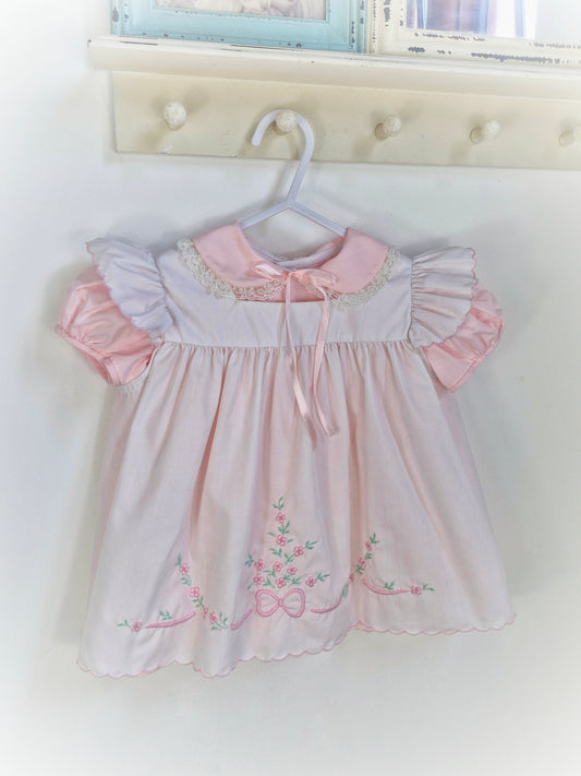 12-18 months. Two piece Nannette vintage pink dress with white pinny embroidered with flowers and bows.