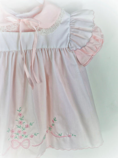 12-18 months. Two piece Nannette vintage pink dress with white pinny embroidered with flowers and bows.