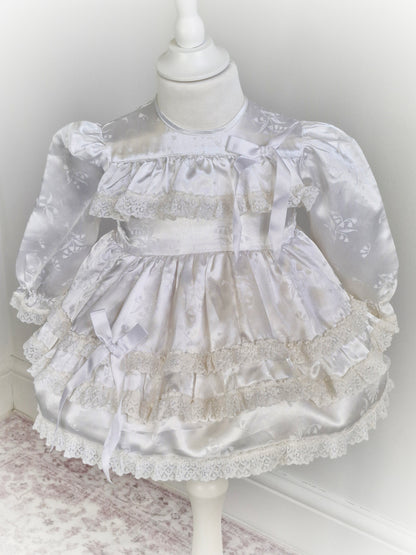 12-18 months. White satin dress with puffed sleeves, ribbon and lace