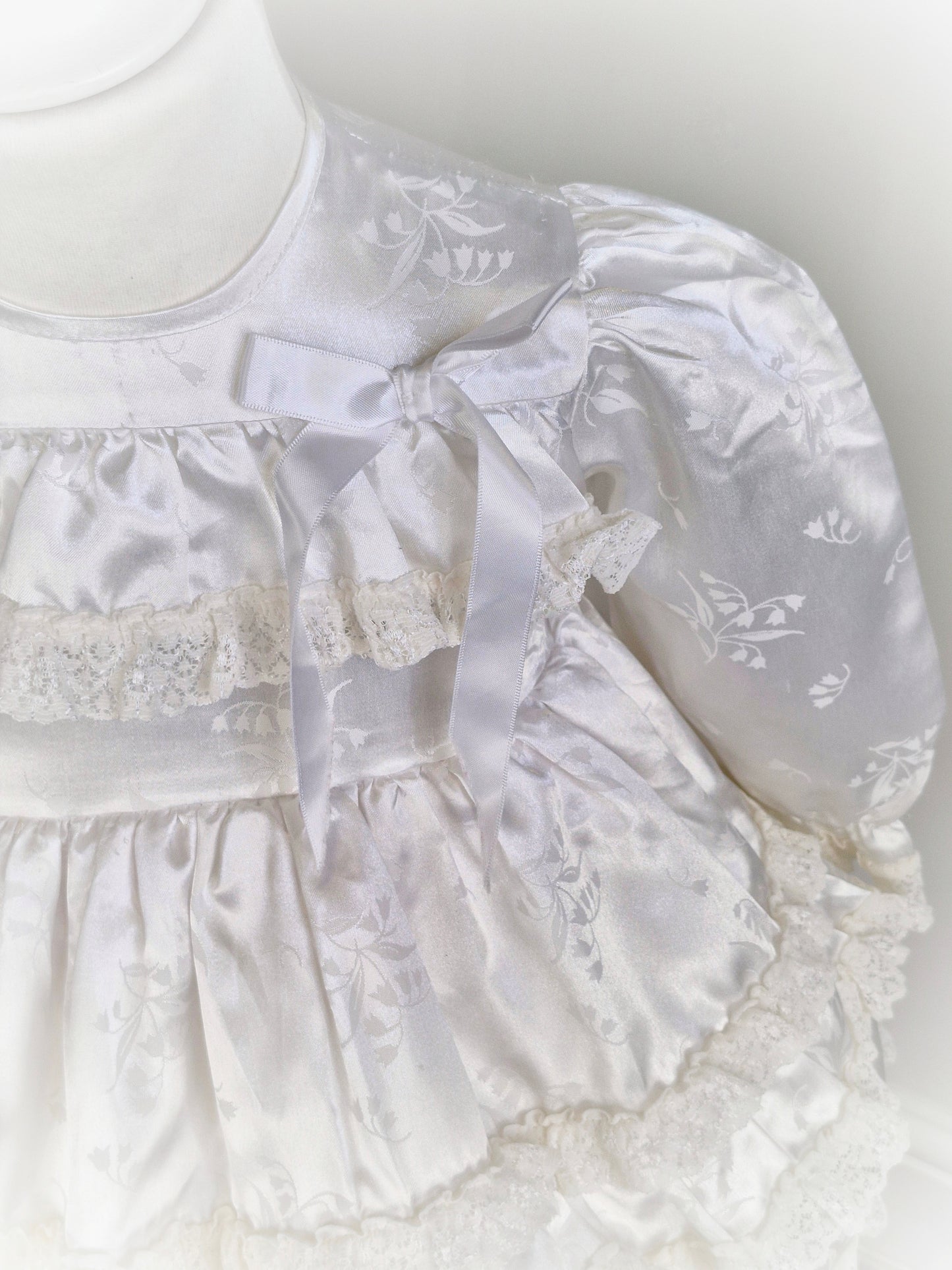 12-18 months. White satin dress with puffed sleeves, ribbon and lace