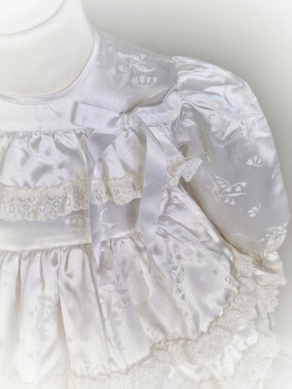 12-18 months. White satin dress with puffed sleeves, ribbon and lace