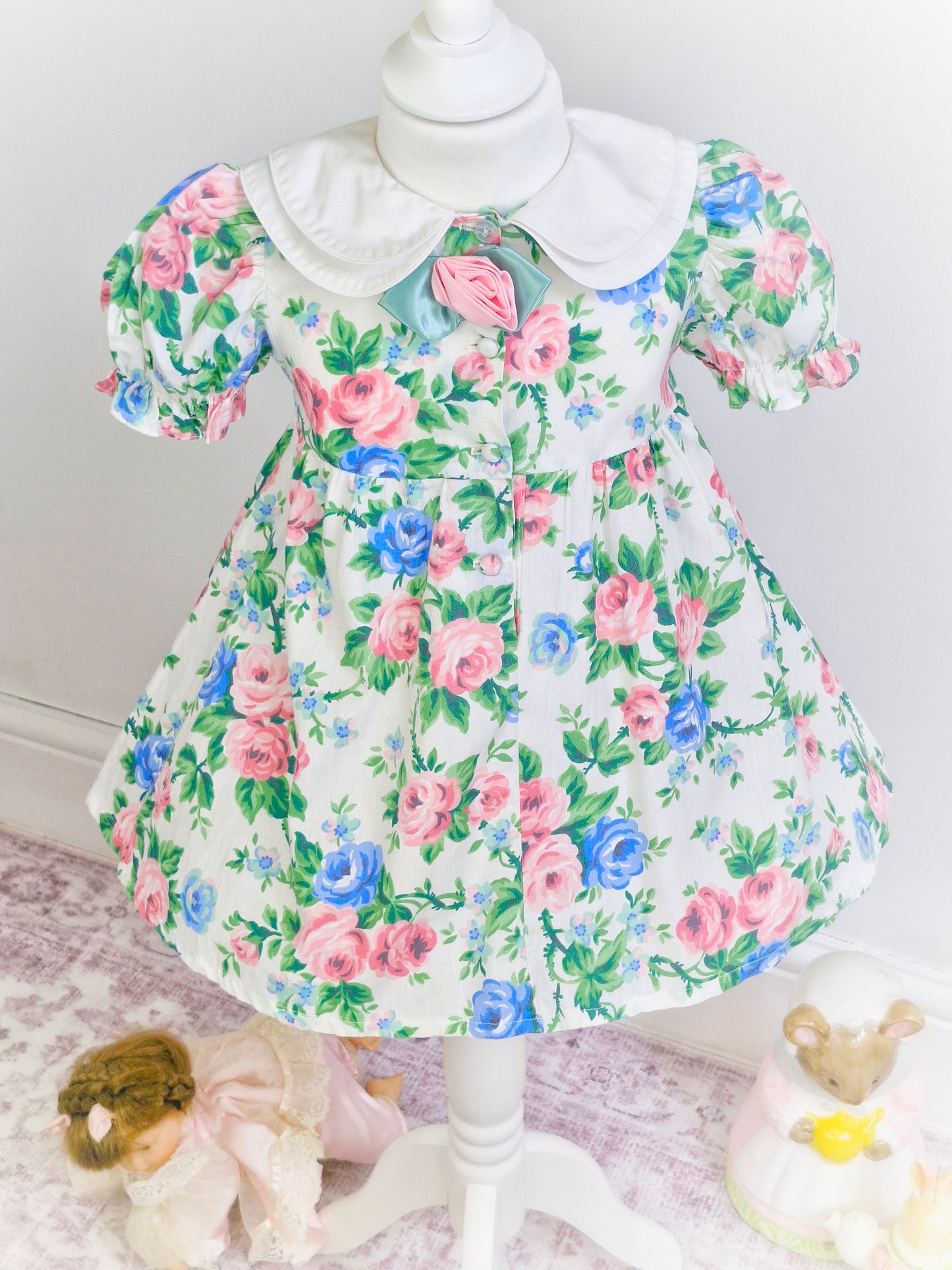 3 years. Blue and pink floral dress with double white collar and rose centre