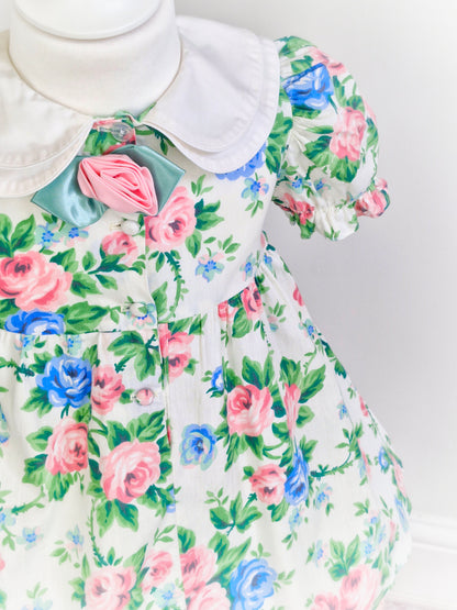 3 years. Blue and pink floral dress with double white collar and rose centre
