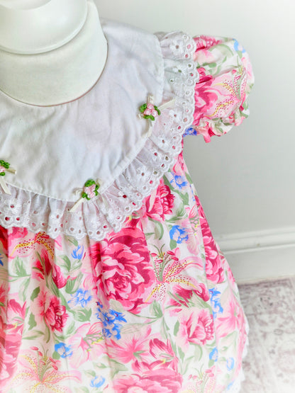 2 years. Pink vintage floral dress with white bib, rosettes and broderie anglais trim