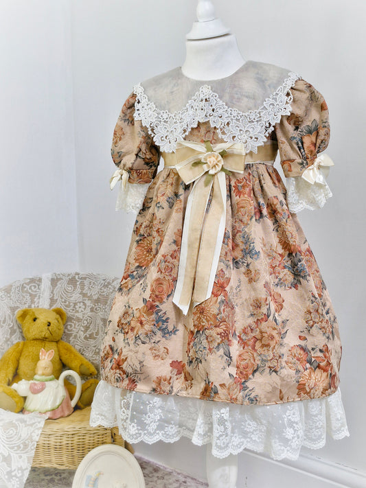 5 years. Large white bib with lace details, sleeves and hem. Floral, puff sleeves and cream waistband