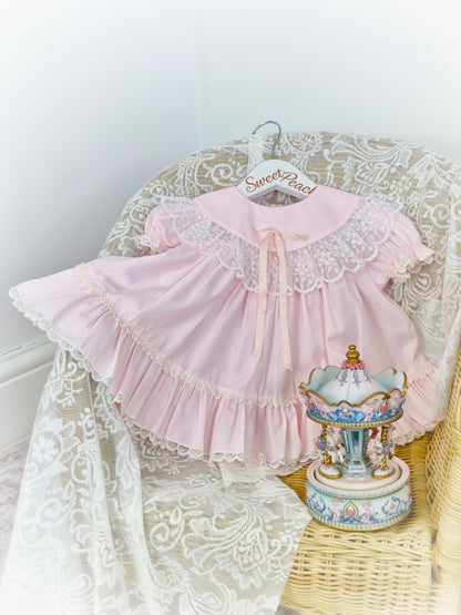 9-12 months. Pink vintage Bryan with lace trim on bib and hem