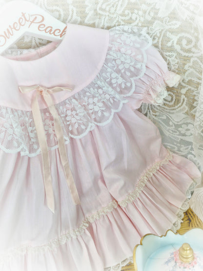 9-12 months. Pink vintage Bryan with lace trim on bib and hem