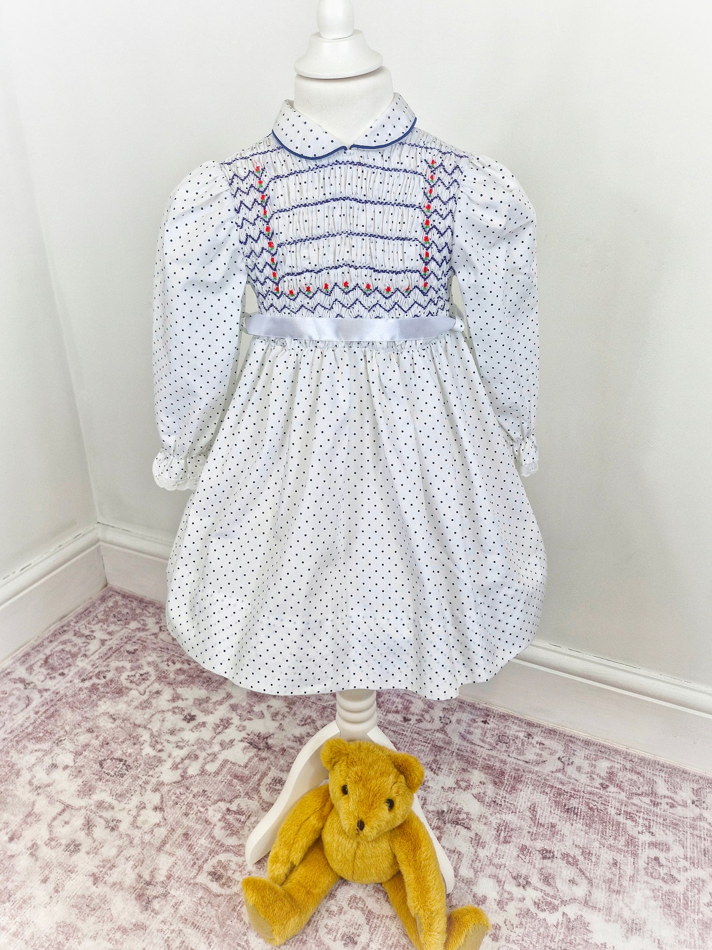 4 years. White Polly Flinders smocked dress with navy polka dots and embroidery