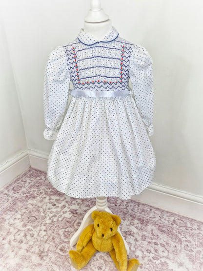 4 years. White Polly Flinders smocked dress with navy polka dots and embroidery