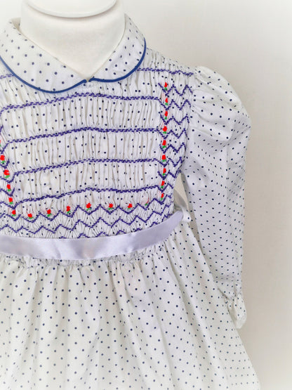 4 years. White Polly Flinders smocked dress with navy polka dots and embroidery