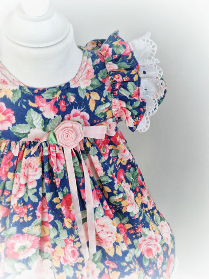 2 years. Navy and pink floral dress with white broderie anglais flutter sleeves and hem from Rare Editions
