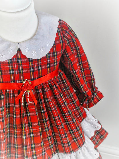 2 years. Red tartan dress with white collar embroidered with dainty flowers. Ribbon belt.