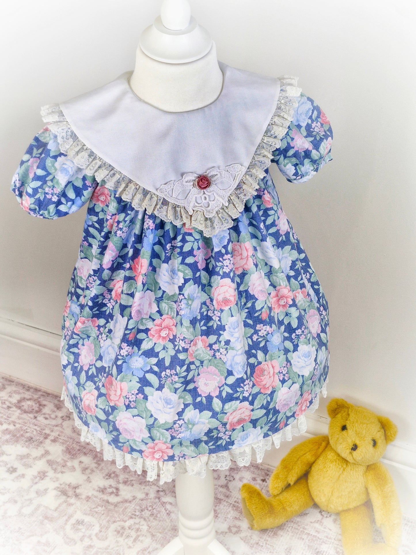 2-3 years. Blue floral vintage dress from Special Occasions with lace hem and bib