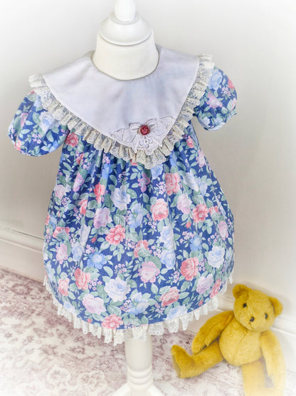 2-3 years. Blue floral vintage dress from Special Occasions with lace hem and bib