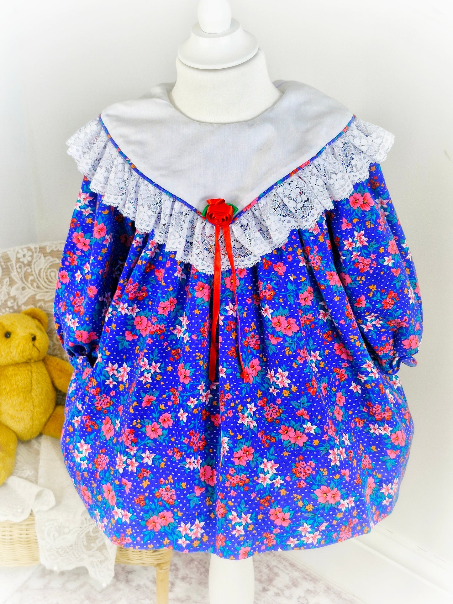 2-3 years. Royal blue vintage Jolene with flowers, white bib and lace details