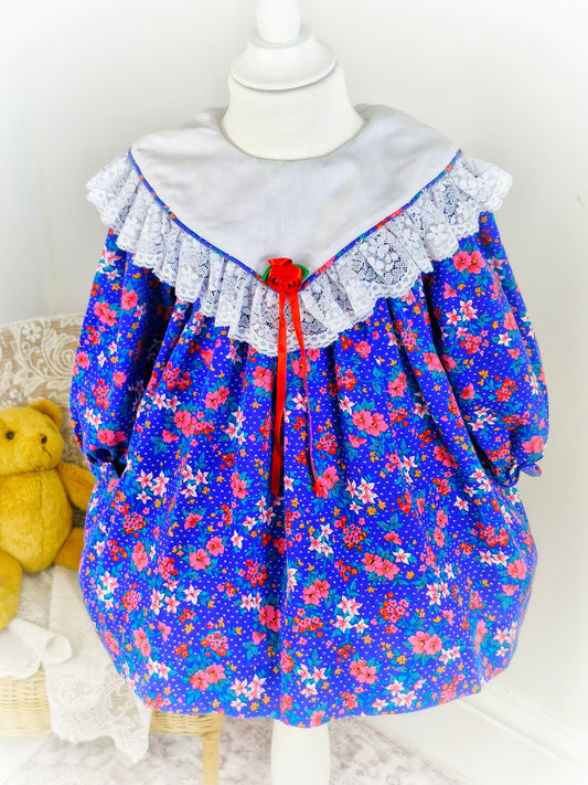2-3 years. Royal blue vintage Jolene with flowers, white bib and lace details