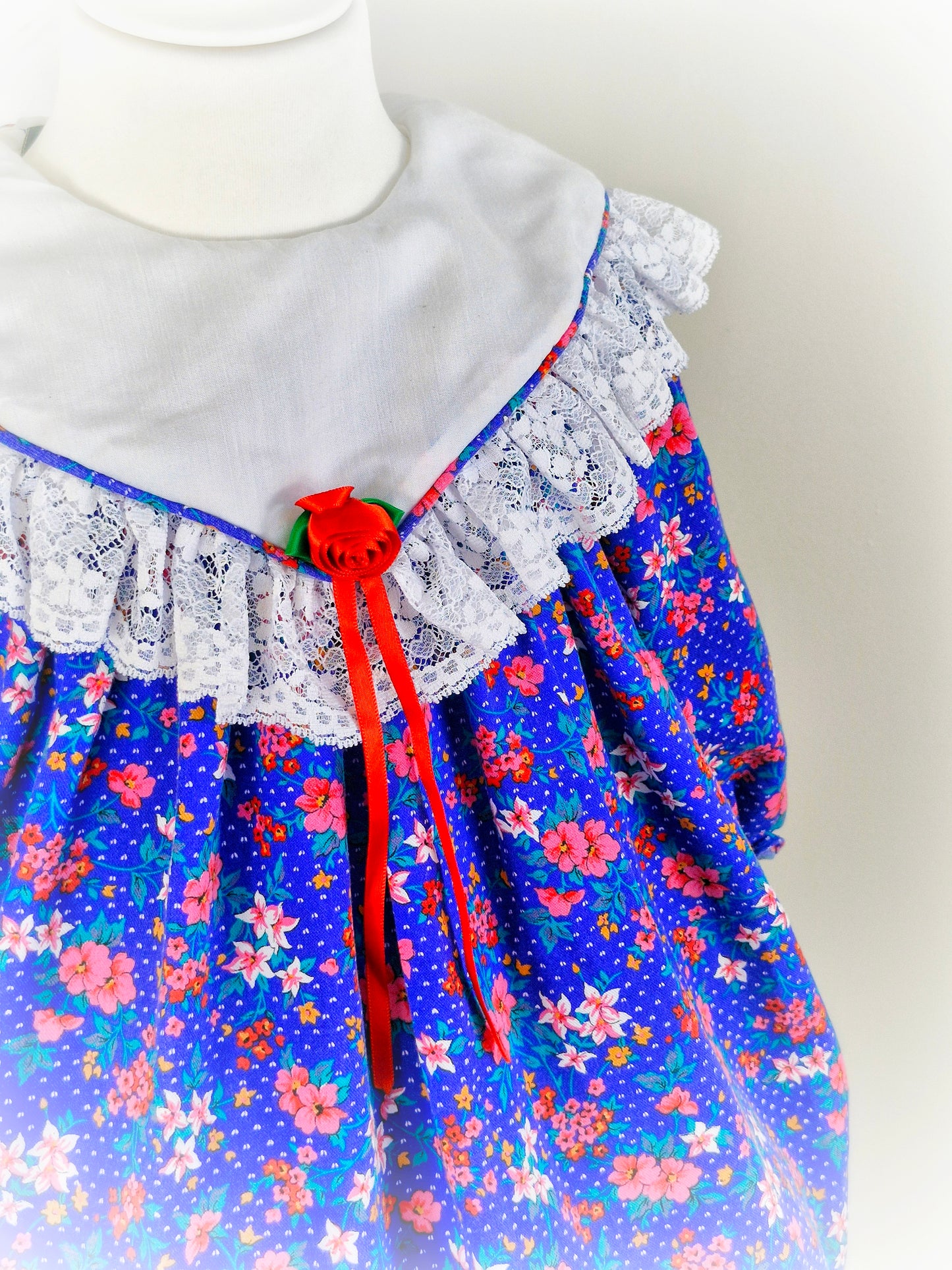 2-3 years. Royal blue vintage Jolene with flowers, white bib and lace details