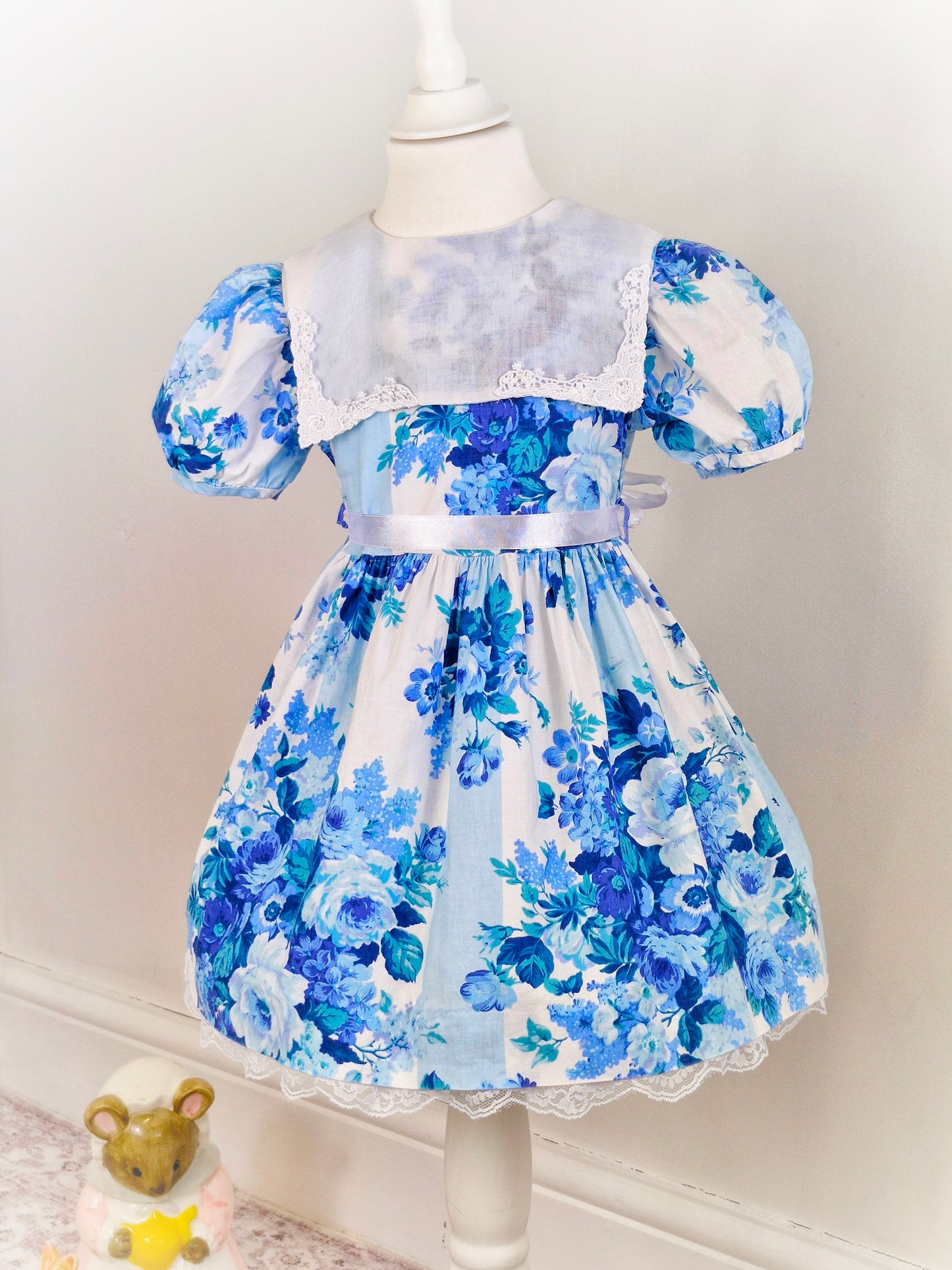 4 years. Good Lad of Philadelphia, white dress with blue floral print, puff sleeves and white bib