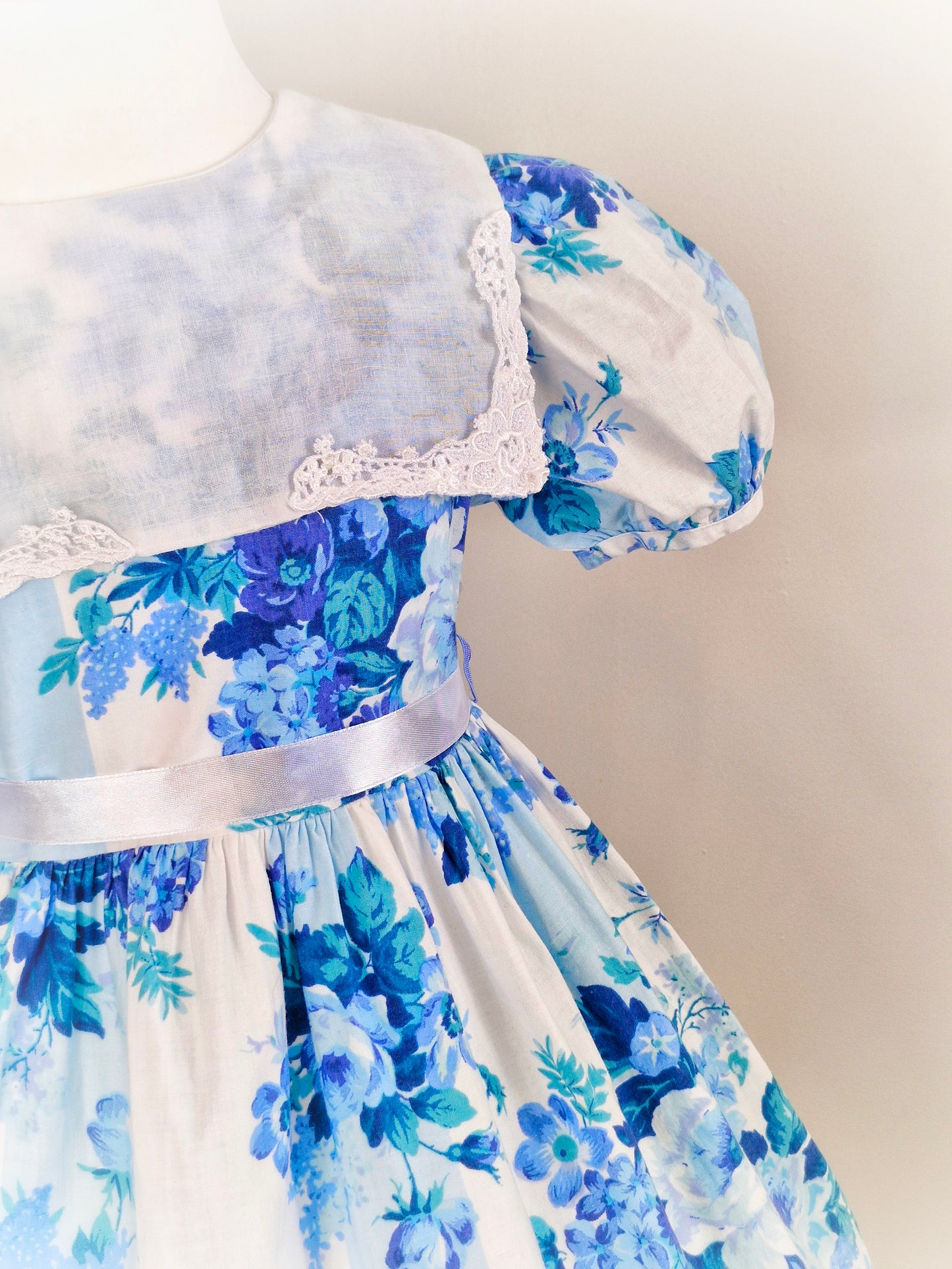 4 years. Good Lad of Philadelphia, white dress with blue floral print, puff sleeves and white bib