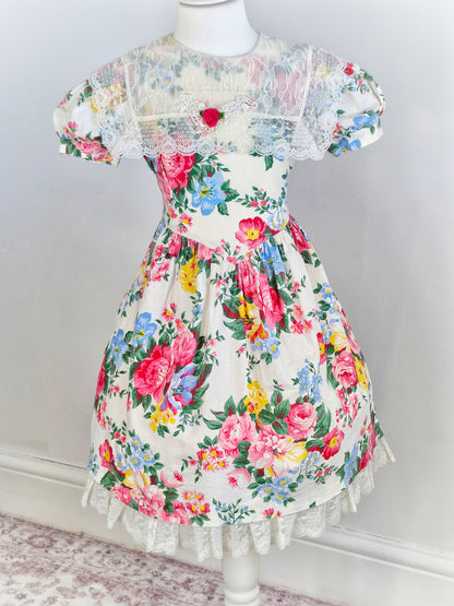 6-7 years. Beautiful floral vintage dress by Picture Perfect with lace bib and hem