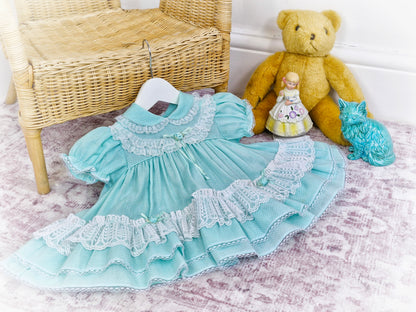 9-12 months. Vintage Petit Jouet, mint dress with white lace and rosettes