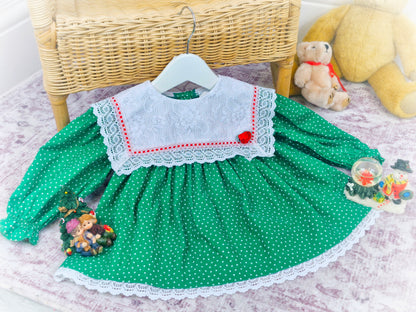 9-12 months. Green vintage Bryan with star print, white lace bib and red details